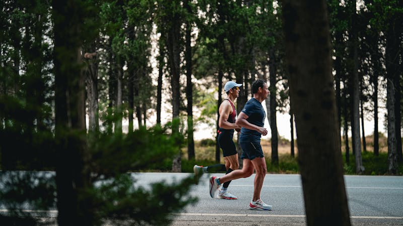 Two people on a recovery run along a quiet forest road